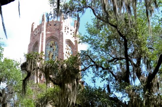 The southwest side of the top of Bok Tower, Florida, seen through the branches of the numerous spreading oaks of the sanctuary.